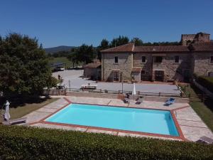 a large swimming pool in front of a house at Podere La Selva in Rapolano Terme