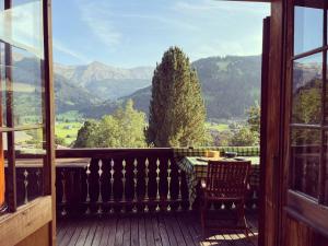 a balcony with a table and a view of mountains at Apartment Steirösli 1- & 2- Stock by Interhome in Lenk
