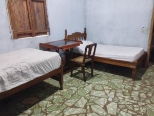 a room with two beds and a desk and a chair at Rancho Belen in Isla de Ometepe
