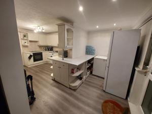 a kitchen with white cabinets and a refrigerator at Private Home Grays in Orsett