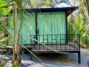 a green structure sitting in the middle of a forest at Céu da Terra in Colinas Do Sul