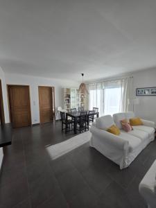 a living room with a white couch and a table at maison être mer et montagne in Ponte-Leccia