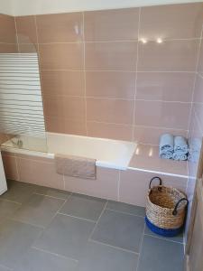 a bathroom with a tub and a basket at maison être mer et montagne in Ponte-Leccia +14 photos