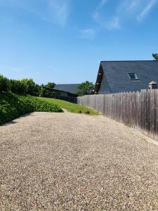 a gravel driveway next to a fence and a house at Bel Air Studios-Terrasse couverte-Jardinet-Vue Pont de Normandie-Parking privé in Honfleur