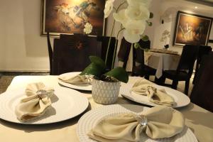 a table with white plates with bows and flowers at Hotel Inambu Villavicencio in Villavicencio +84 photos