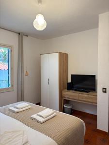 a bedroom with a bed with a tv and a cabinet at Casa Conceição in Ribeira Brava