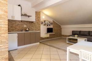 a kitchen and living room with a couch and a table at Villa San in Neum