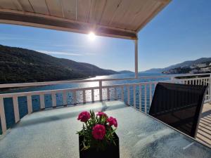 a table with a vase of flowers on a balcony at Villa San in Neum