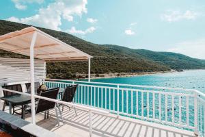 a deck with chairs and a view of the water at Villa San in Neum