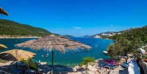 a beach with umbrellas and a body of water at Villa San in Neum