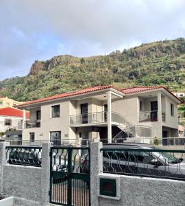a building with a balcony with a mountain in the background at Casa Conceição in Ribeira Brava