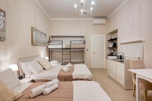 a bedroom with two beds and a kitchen in it at Your House Rooms in Genoa
