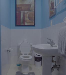 a bathroom with a white toilet and a sink at Getaway Homes in Basseterre +26 photos