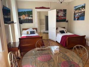 a room with two beds and a table and chairs at La glacière in Périgueux