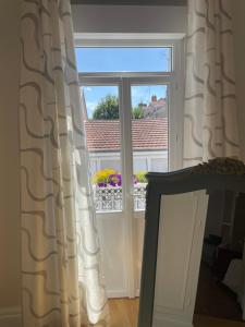 a window with a view of a balcony with flowers at La glacière in Périgueux