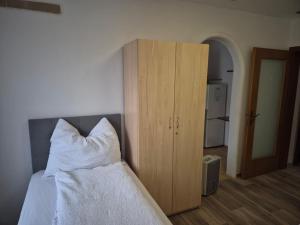 a bedroom with a bed and a wooden cabinet at Apartment Krummnußbaum, Donau & Wachau in Krumnussbaum an der Donauuferbahn