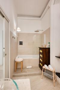 a bathroom with a tub and a table and a stool at Your House Rooms in Genoa +66 photos