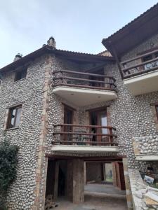 a stone house with a balcony on the side of it at Kalavrita Mons in Kalavrita