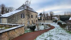 an old stone building with snow on the ground at Ma Location Saisonnière in Chasseneuil-du-Poitou