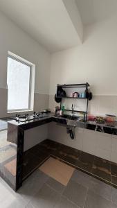 a kitchen with a sink and a window at Homestay Azizi in Seri Iskandar +5 photos