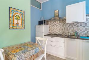 a kitchen with white cabinets and a table and a sink at Casacecilia relax in Syracuse