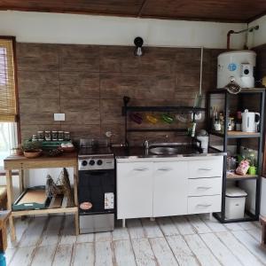 a kitchen with a sink and a stove at Entre Tanto in Luyaba