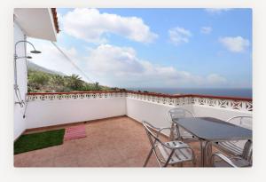 a balcony with a table and chairs and the ocean at Villa Luisa Atico in Tigaday