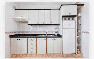 a kitchen with white cabinets and a refrigerator at Villa Luisa Atico in Tigaday