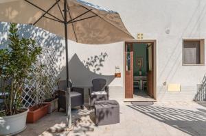 a patio with an umbrella and a table and chairs at Casacecilia relax in Syracuse