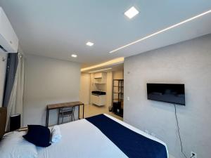 a bedroom with a bed and a tv on a wall at Home Studio in Sobral