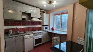 a kitchen with a sink and a stove top oven at Home for you in Ternopil