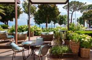a patio with a table and chairs and plants at Park Hotel in Desenzano del Garda