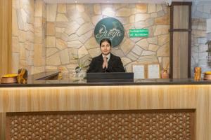 a woman standing behind a counter with a laptop at Divya Boutique Inn in Kathmandu