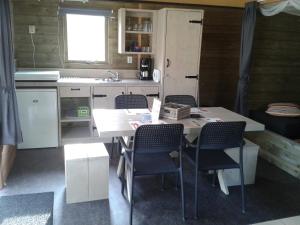 a kitchen with a table and chairs in a room at 5 persoons lodge in Witmarsum