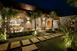 a courtyard with palm trees in front of a building at Dania Cinta Ubud in Ubud