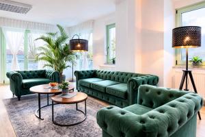 a living room with two green couches and a table at The Business Loft in Wolfsburg