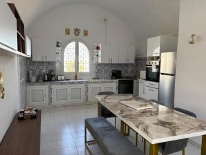 a kitchen with white cabinets and a marble counter top at Casa Madame Aïcha in Sousse