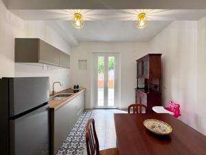a kitchen with a wooden table and a refrigerator at Ama Family in Marotta