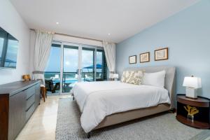 a bedroom with a bed and a view of the ocean at Ruby - 2-bed condo with pool in Saint Georgeʼs +14 photos