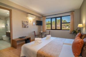 a bedroom with a large bed and a large window at The Pines Hotel in Culla