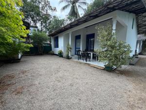 a white house with a table and chairs at Peacock grand resort in Kataragama