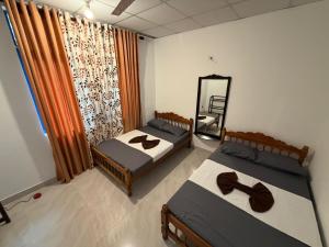 a bedroom with two beds and a mirror in it at Peacock grand resort in Kataragama