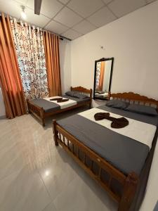 a bedroom with two beds and a large window at Peacock grand resort in Kataragama
