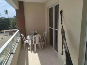 a balcony with a table and chairs on a building at Dunas de Guarajuba in Camacari