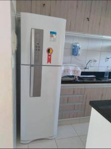 a white refrigerator with a sticker on it in a kitchen at Dunas de Guarajuba in Camacari