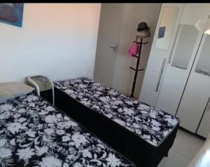 a bedroom with two beds with a black and white blanket at Dunas de Guarajuba in Camacari
