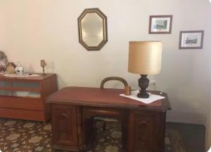 a table with a lamp and a dresser in a room at Via Roma 131 in Montevarchi
