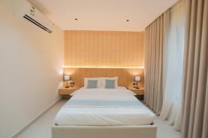 a bedroom with a large bed with two tables and two lamps at Luxury & Modern Brand New Family Apartments in Medina