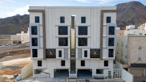 a building under construction with mountains in the background at Luxury & Modern Brand New Family Apartments in Medina