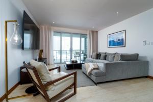 a living room with a couch and a chair at Ruby - 2-bed condo with pool in Saint Georgeʼs